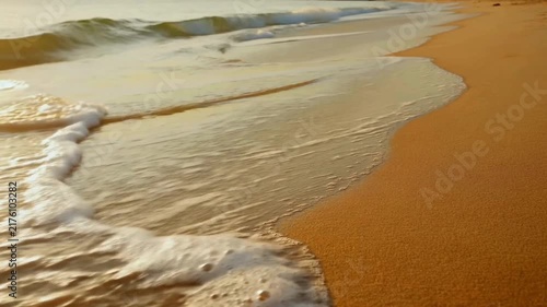 Waves sweep over the sand on the beach.