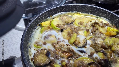 Opening the oven door to reveal roasted fish and vegetables in a glass dish, fresh homemade meal, cooking success, dinner time.