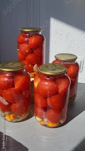 Detailed view of pickled tomatoes in glass jars for winter season, healthy homemade nutrition, autumn food preservation, rustic lifestyle.