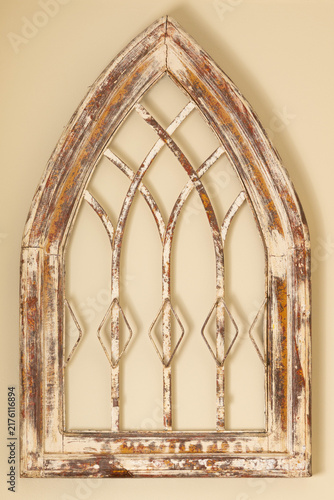 Fotografía Distressed, Gothic-arched wooden and metal church window frame from circa early 1900, with weathered white, red, and brown finish