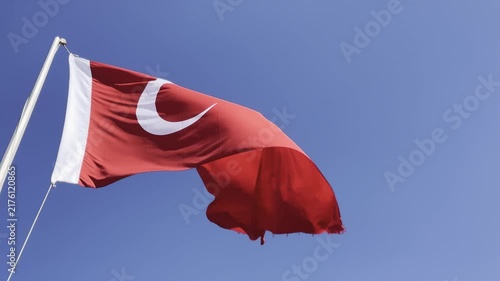 Turkish flag waving proudly in the wind against a clear blue sky, capturing the majestic details of the crescent and star in high-quality 4K footage, perfect for national holidays, patriotic themes, a