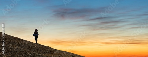 climber or hiker or tourist on sunset sky background