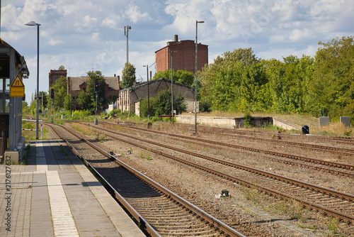Ansicht des historischen Bahnhofsgebäudes mit Gleisanlagen und Bahnsteigen in Könnern an einem sonnigen Tag, Salzlandkreis, Sachsen-Anhalt, Deutschland