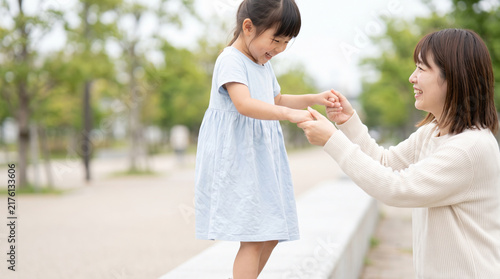 Obraz na płótnie 公園で手をつないで笑顔で遊ぶ親子と子供の成長