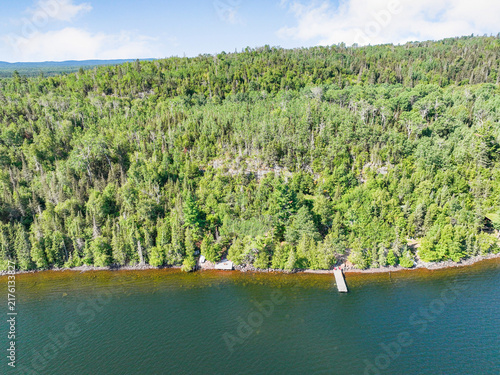 Cuadro en lienzo Aerial photograph of a small wooden dock extending into the clear blue water fro
