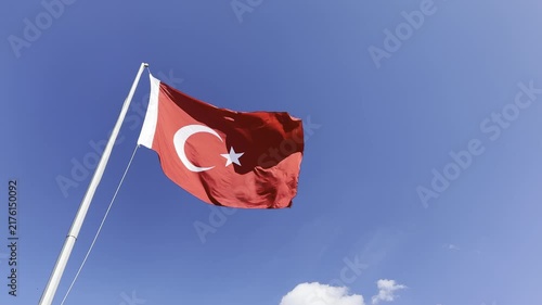 Turkish flag waving proudly in the wind against a clear blue sky, capturing the majestic details of the crescent and star in high-quality 4K footage, perfect for national holidays, patriotic themes, a