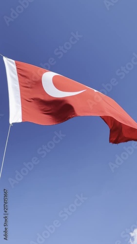 Turkish flag waving proudly in the wind against a clear blue sky, capturing the majestic details of the crescent and star in high-quality 4K footage, perfect for national holidays, patriotic themes, a
