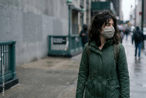 Young woman wearing protective face mask walking on urban city street