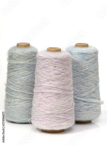 Colorful spools of thread sit together, showcasing a beautiful range of soft shades perfect for any sewing project