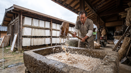 Man Pounding Pulp in Stone Basin for Traditional Paper Production