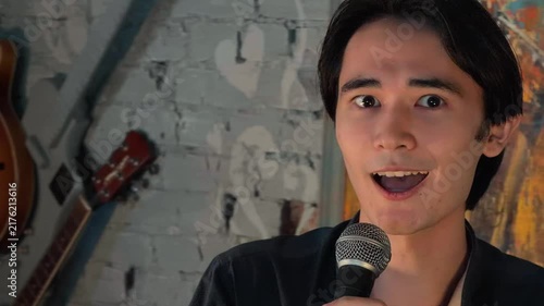 Authentic Close Up Of Expressive Asian Man Overcoming Stage Fright And Speaking Into Microphone During Group Therapy Session In Cozy Cafe Motivating Speech About Mental Health Handheld Shot