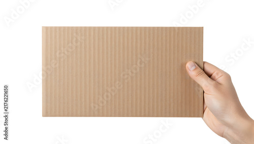 Holding Cardboard: A hand holding a piece of corrugated cardboard, perfect for packaging or design projects.