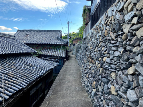 Fotografie 香川県本島の伝統的な家並みを通る細い石垣の路地