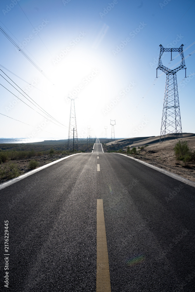 Naklejka premium highway power transmission towers under bright sun