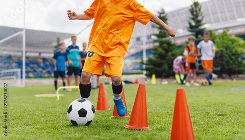 Canvastavla Junior Soccer Player in Orange Uniform Dribbling Ball Through Agility Cones - Yo
