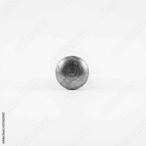 Shiny metallic steel cylinder head sitting centered on plain white studio background showing brushed industrial surface texture and fine scratches