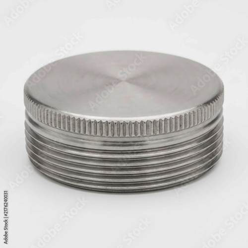 Industrial metal cap featuring detailed threaded edges and a circular smooth top surface isolated on a clean white studio background