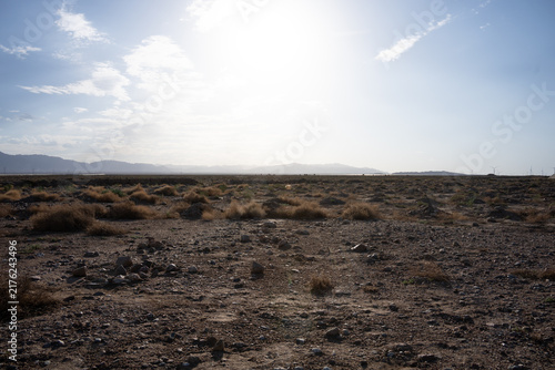 фотографія Desert Gobi rocky terrain with distant mountains under bright sky