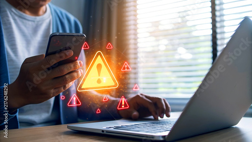 Obraz na płótnie Cybersecurity threat warning on laptop and mobile phone screen, highlighting the