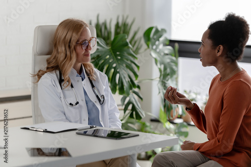 Female patient discussing health concerns with an attentive doctor during a professional medical consultation