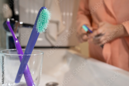 Fotografie Two toothbrushes, old and new, held on a bathroom counter to highlight timely re