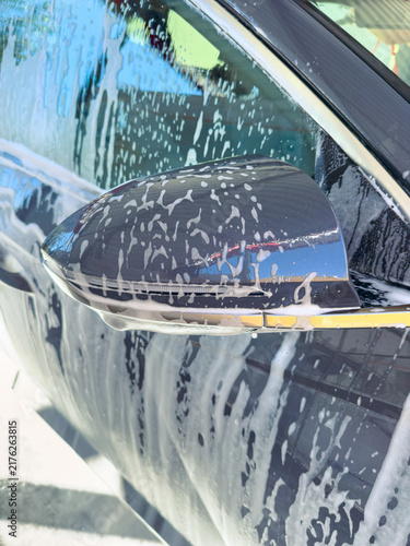 Принти на полотні Car is being washed at a cleaning station during the day with soap covering the