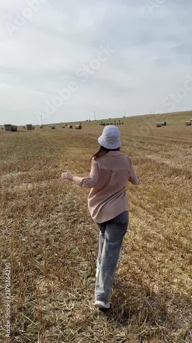 Young Woman Running In Field With Hay Bales Video