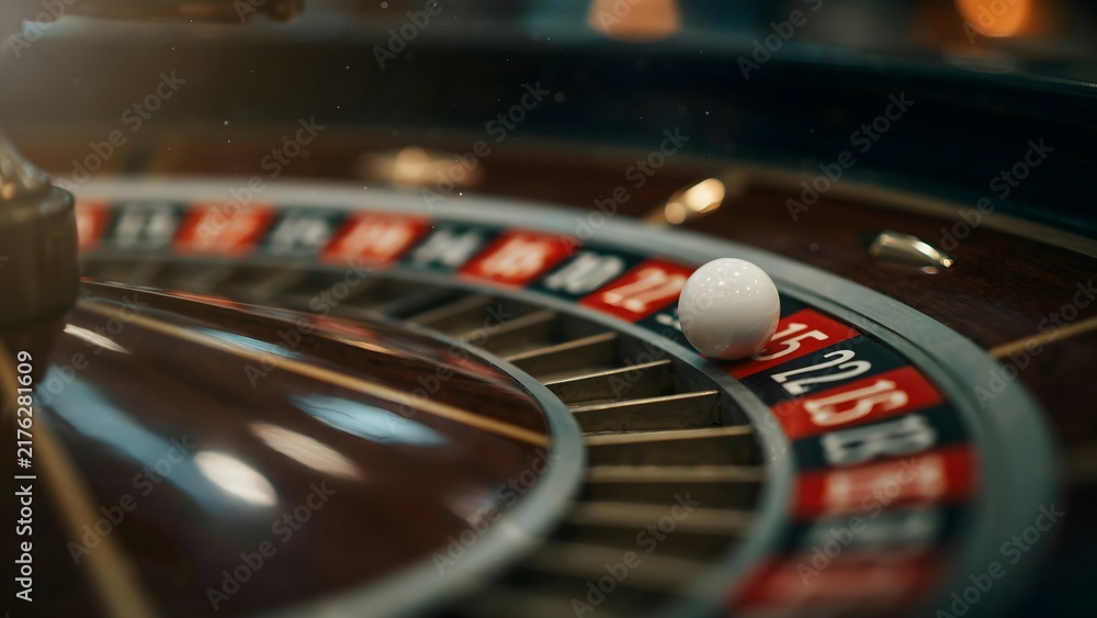 Obraz premium Roulette Wheel with a White Ball on a Casino Gaming Table