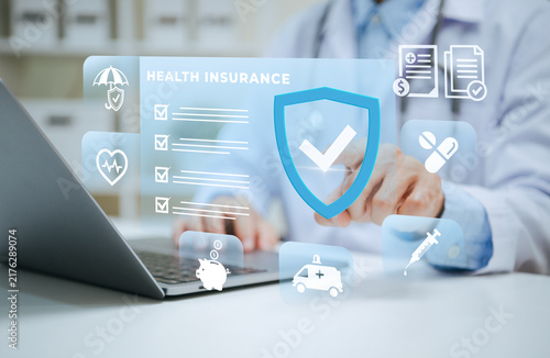 Foto Doctor reviewing health insurance coverage on laptop managing medical claims pol