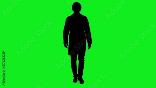 Silhouette of a doctor or scientist walking forward on a green screen chroma key background