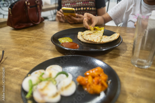 Indian Flatbread with Chutneys and Pickles at a Restaurant