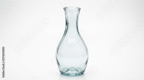 Glass carafe bottle empty standing upright on a clean plain white background surface