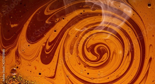 Swirling chocolate liquid with droplets.