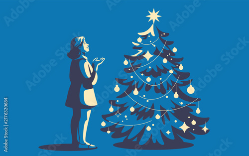 Woman looking at decorated christmas tree with glowing ornaments and star top