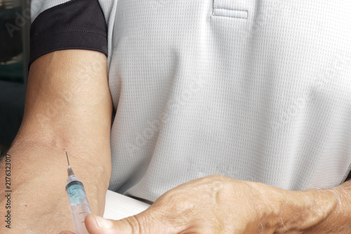 Man Injecting Himself with a Syringe in Arm
