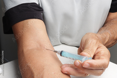 Man Injecting Himself with a Syringe in Arm