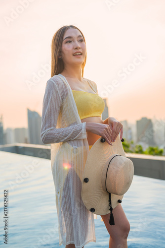 Cuadro en lienzo Playful joyful young woman laughing with closed eyes holding straw hat at rooftop pool sunset, enjoying vacation bliss, freedom, luxury leisure, wellbeing, and cheerful vitality