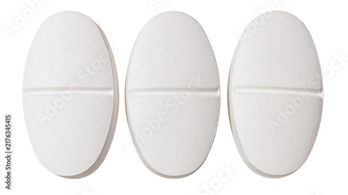 Foto Three white oval shaped pharmaceutical pills with a center score line