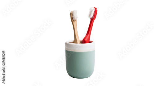 Obraz na plátne Bamboo and red plastic toothbrushes in a two-tone sage green ceramic cup holder