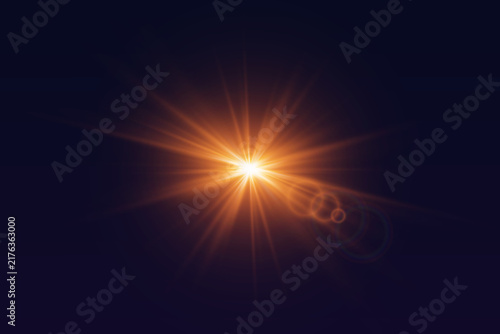 Bright orange starburst lens flare with light beams on dark background