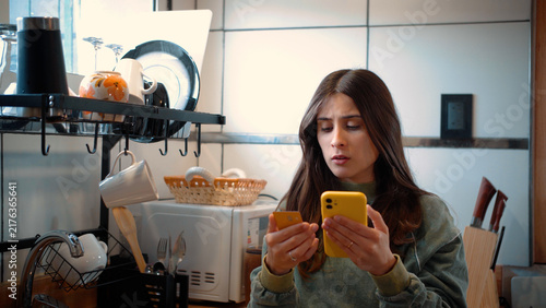 Cuadro en lienzo Frustrated young Latina woman in her kitchen unable to complete an online purchase, representing digital barriers, consumer frustration, and modern financial challenges