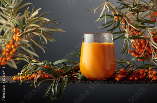 Konstfotografi Glass of sea buckthorn juice with fresh berries on a branches.