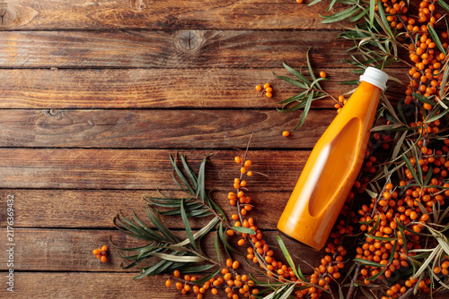 Foto Bottle of sea buckthorn juice with fresh berries.