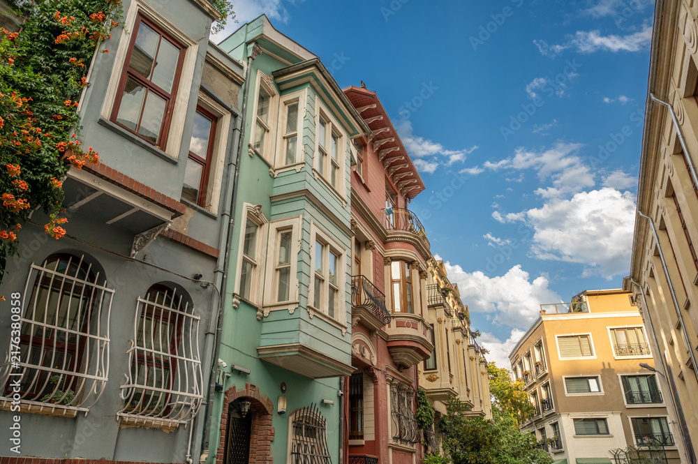 Obraz premium Istanbul,turkey,august 2, 2025. Colorful historic houses lining a street in balat, istanbul, turkey, displaying traditional architecture under a blue sky
