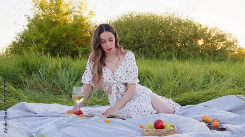 A Woman Enjoying Snacks and Wine on a Beautiful Blanket at a Picnic