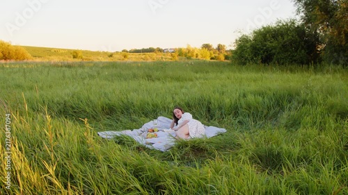 Enjoying a relaxing picnic in a serene green field at sunset
