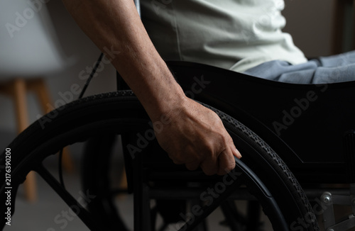 Bild auf Leinwand Close-up of an older adult hand gripping a wheelchair wheel at home, highlighting mobility, disability, independence, accessibility, rehabilitation, strength and daily adaptive living