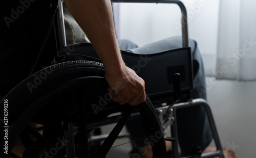 Foto Close-up rear view of an older adult gripping a manual wheelchair wheel indoors, highlighting disability equipment, personal mobility, self-reliance, accessibility and independent movement