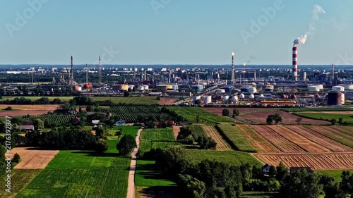 Aerial view of Orlen Plock Production Plant with industrial chimneys, storage tanks, and surrounding agricultural fields in Plock, Mazowieckie, Poland.