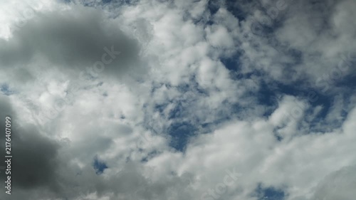 Timelapse of white summer clouds drifting across a dark blue sky
